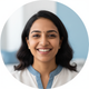 Smiling Indian woman in her late 20s, looking at the camera, suggesting relief and happiness.